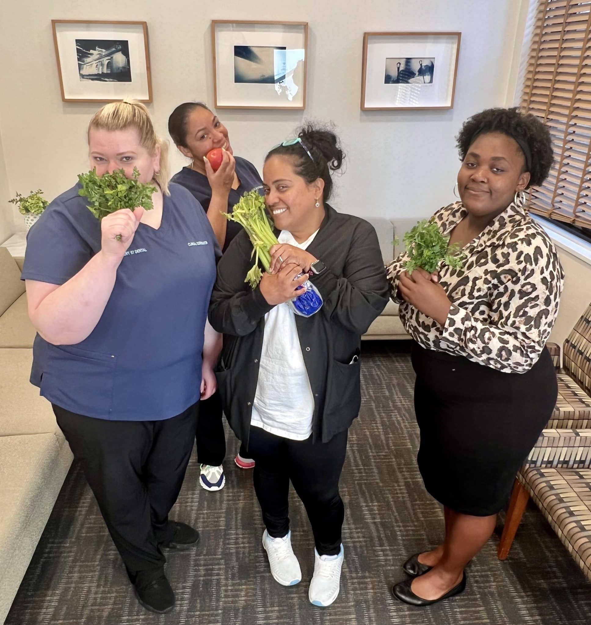 A group of dental team members holding fresh herbs and vegetables, highlighting natural ways to improve breath instead of relying on mints – do tic tacs help with bad breath