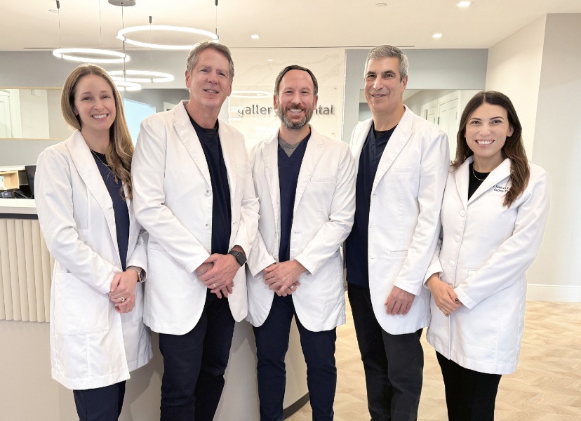 Friendly and experienced dental professionals standing together inside a modern New York City dental office, showcasing a welcoming team dedicated to comprehensive and patient-focused dental care – dentist nyc